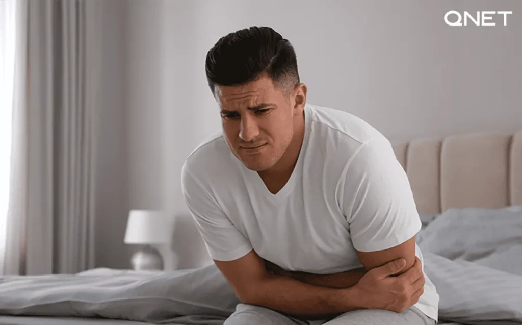 A man holding his stomach due to stomach problems