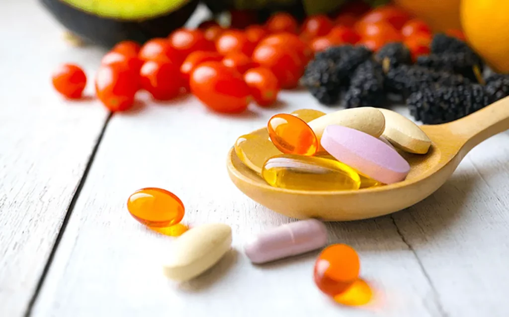 A white bottle with coloured pills and multivitamin tablets on blue background
