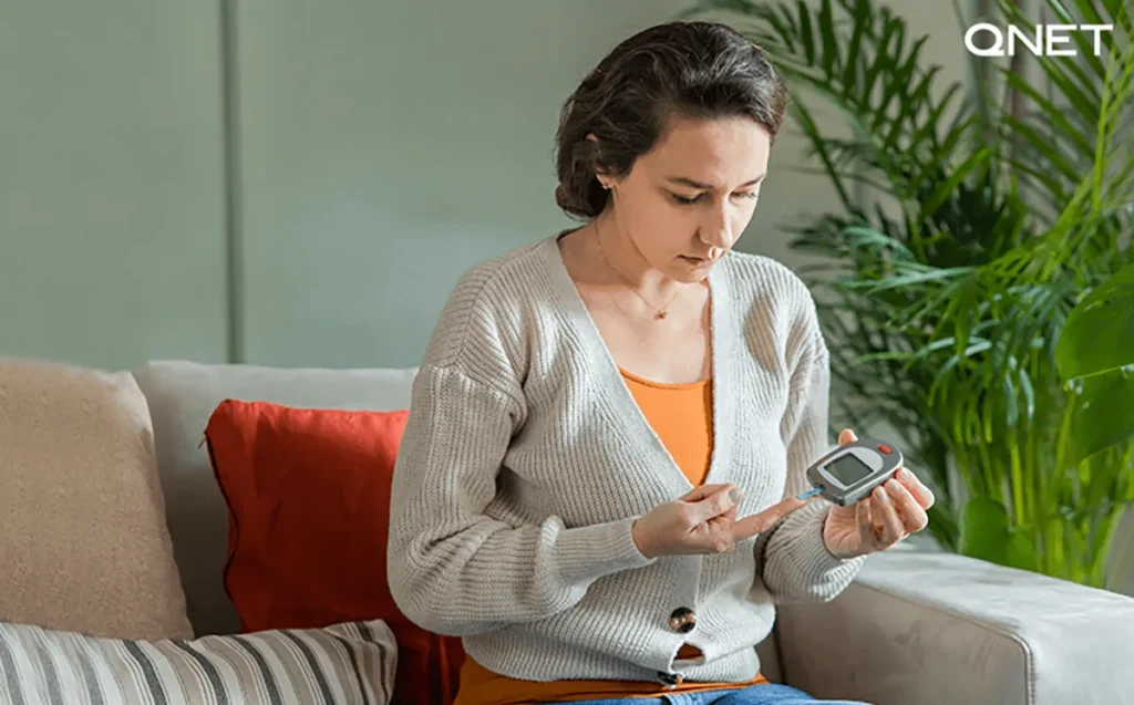 A young woman testing her blood sugar levels at home