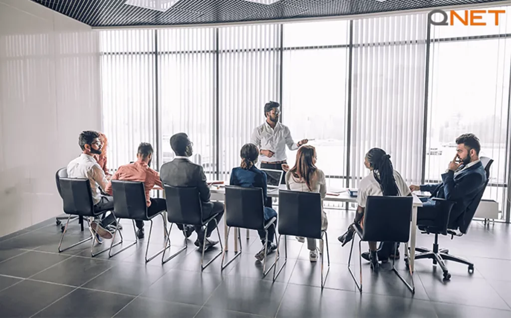 QNET distributors during an indoor meeting discussing their role in establishing professional ethics in direct selling
